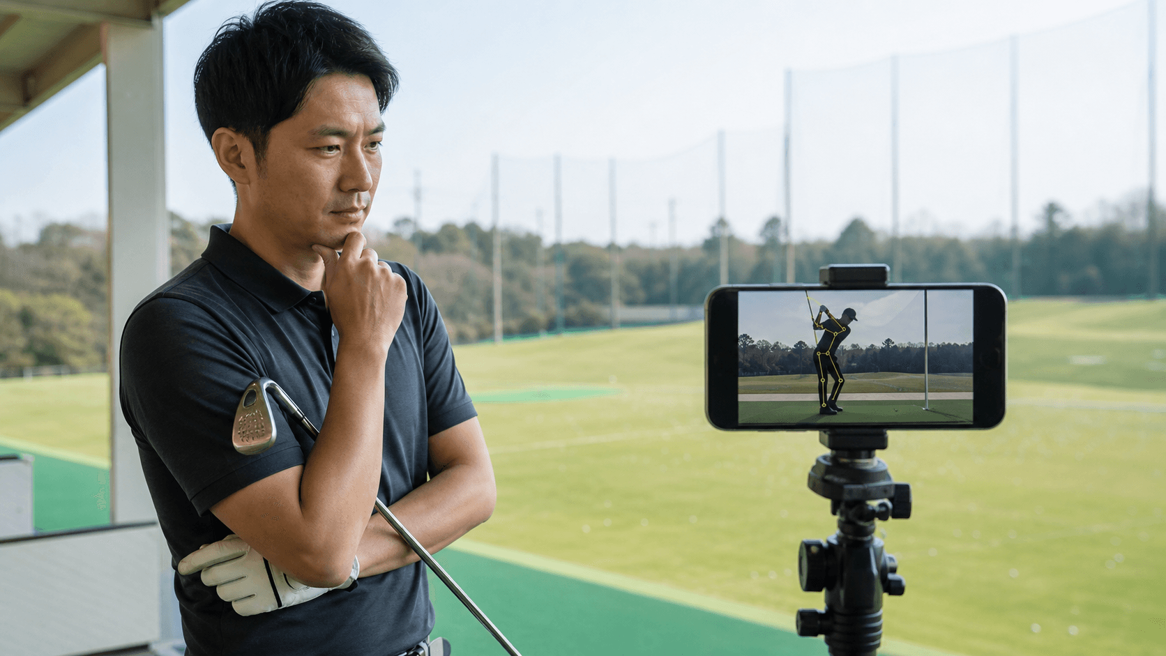 A golfer reviewing an AI swing analysis on a smartphone mounted on a tripod